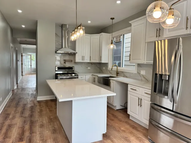 a kitchen with stainless steel appliances a refrigerator a sink and a stove