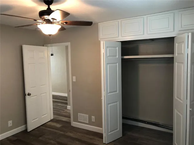 a view of a refrigerator in kitchen and white cabinets