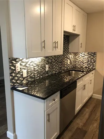 a kitchen with granite countertop a sink and a stove