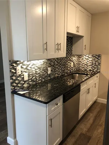 a kitchen with granite countertop a sink and a stove
