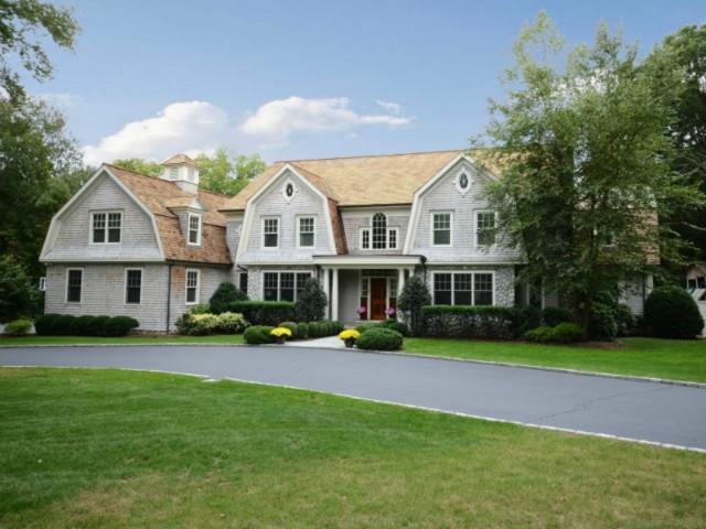 a view of a house with a big yard and large trees