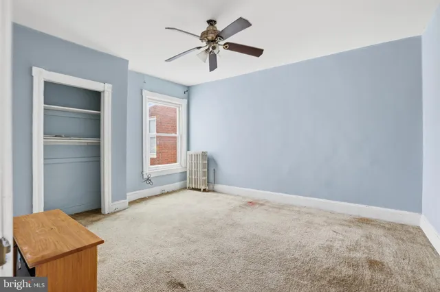 a view of an empty room with a ceiling fan and a window