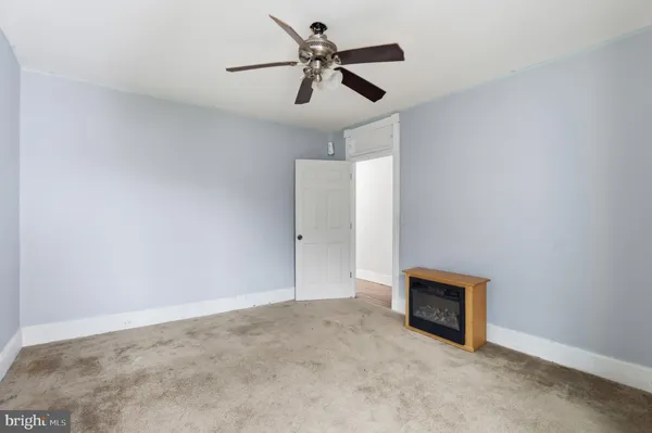 an empty room with closet and a ceiling fan
