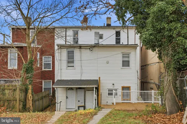 a view of a house with a door and a tree
