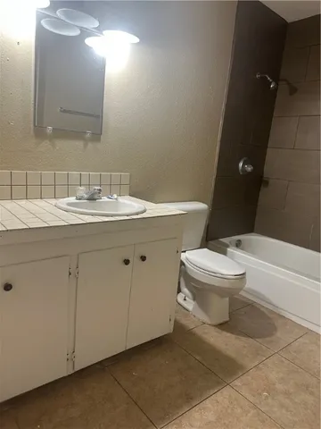 a bathroom with a granite countertop toilet a sink and a mirror