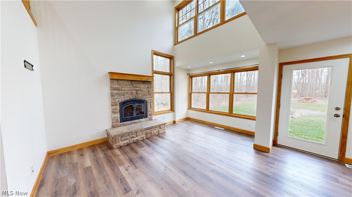 15548 Trask Road Thompson, OH 44086 - Photo 6 of 31 Unfurnished living room with hardwood / wood-style floors and a fireplace
