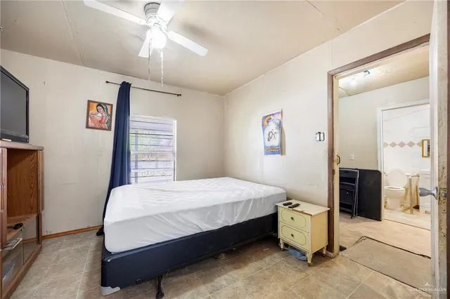 a bedroom with a bed and a flat tv screen on dresser