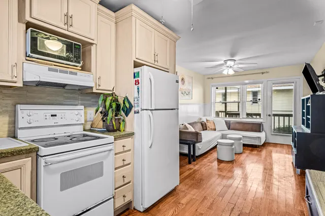 a kitchen with stainless steel appliances a refrigerator stove and wooden floor