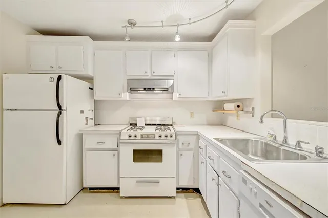 a kitchen with cabinets appliances a sink and a counter top space