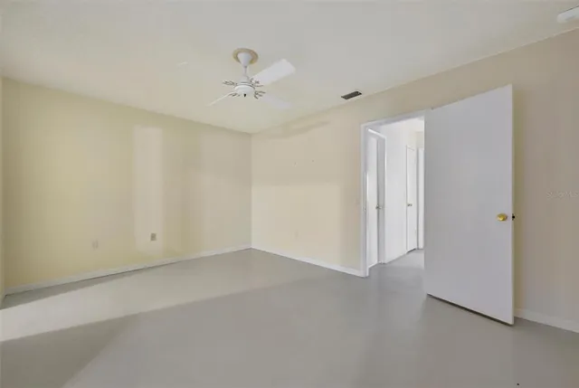 an empty room with a ceiling fan and a window