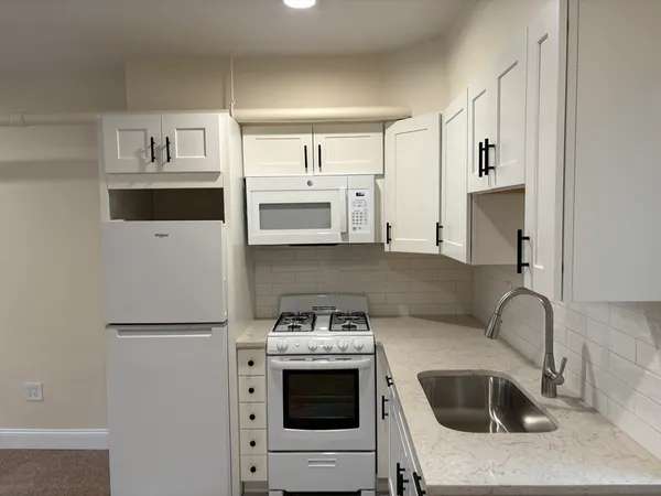a kitchen with stainless steel appliances a stove a microwave and a refrigerator