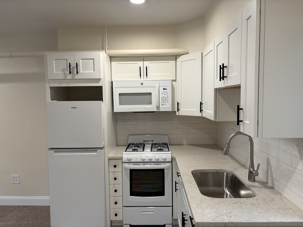 a kitchen with stainless steel appliances a stove a microwave and a refrigerator
