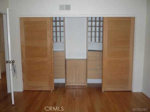 an empty room with wooden floor and closet