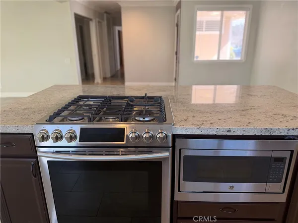 a large kitchen with kitchen island granite countertop a sink and a stove
