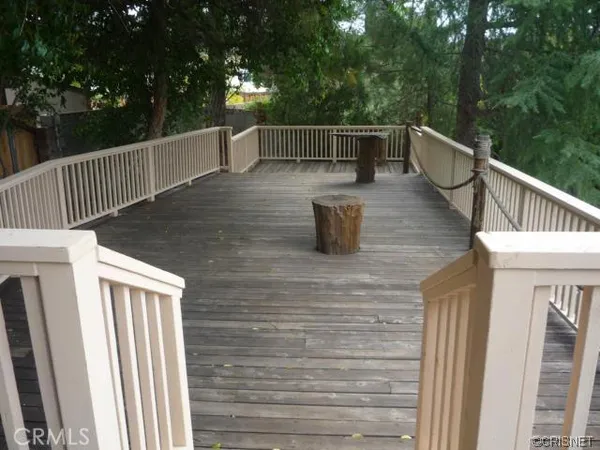a view of deck with furniture and trees