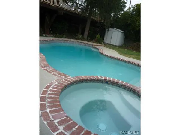 a kitchen with stainless steel appliances granite countertop a stove top oven a sink a dining table and chairs