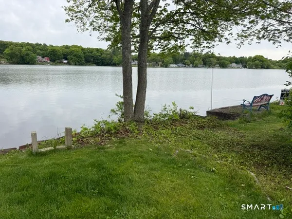 a backyard of a house with lots of green space and lake view