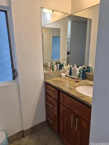 a bathroom with a granite countertop sink and a mirror