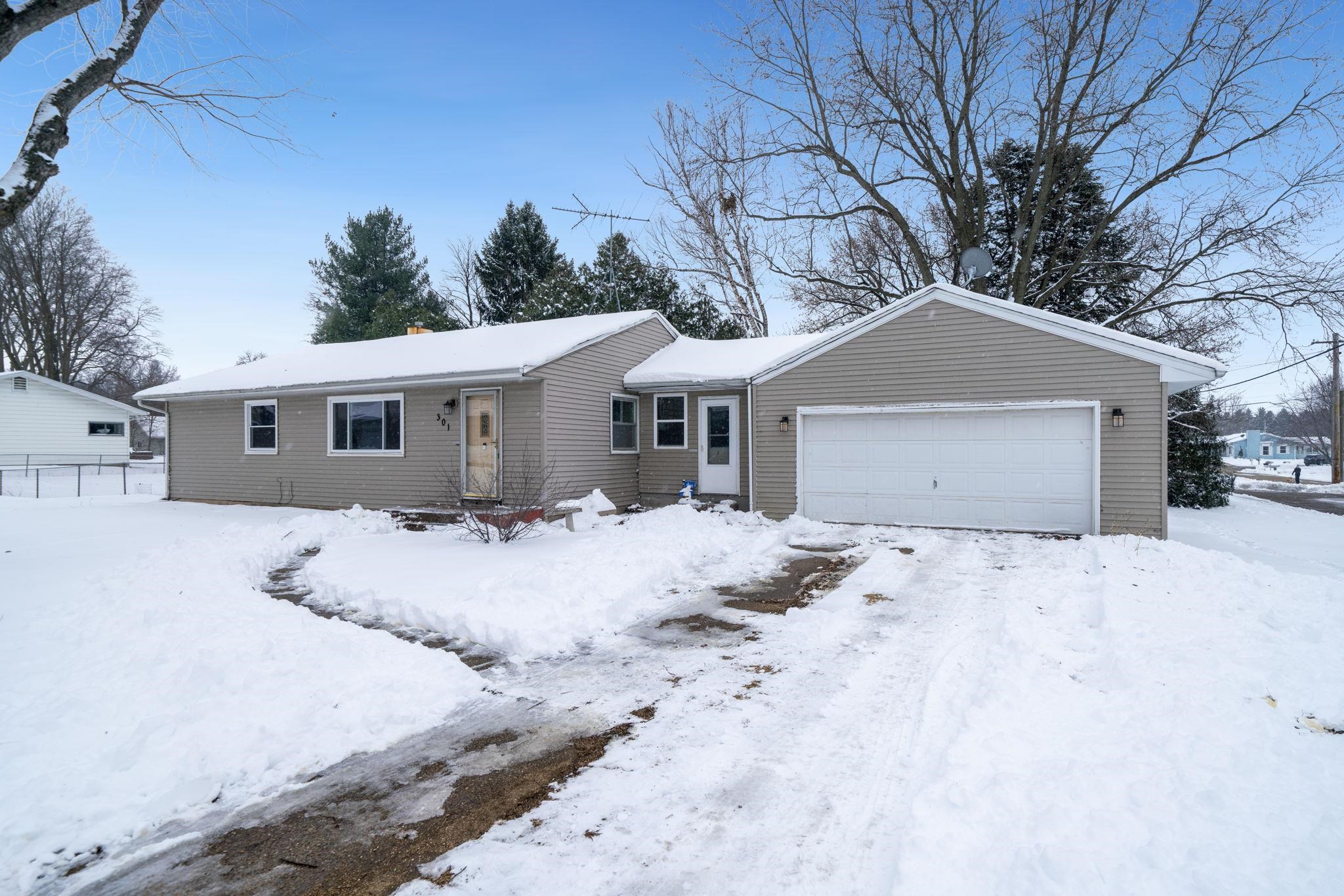 a front view of a house with yard and trees in the background