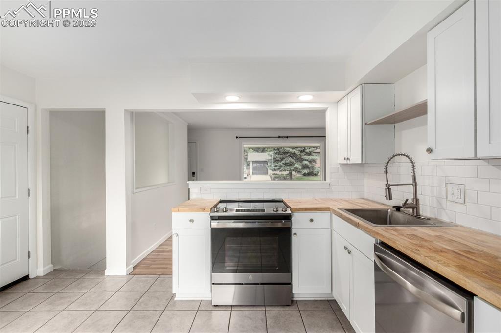 1216 Osgood Road Colorado Springs, CO 80915 - Photo 11 of 36 a kitchen with granite countertop a stove sink and cabinets