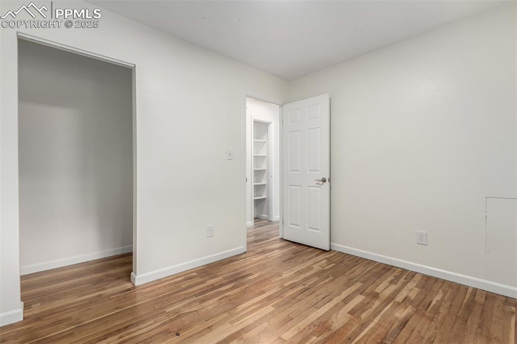 1216 Osgood Road Colorado Springs, CO 80915 - Photo 13 of 36 an empty room with wooden floor and white doors