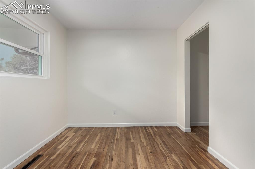 1216 Osgood Road Colorado Springs, CO 80915 - Photo 14 of 36 a view of an empty room with wooden floor and a window