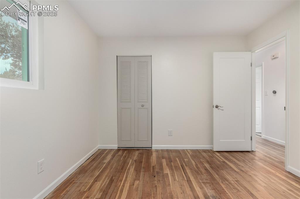 1216 Osgood Road Colorado Springs, CO 80915 - Photo 16 of 36 a view of an empty room with wooden floor and a window