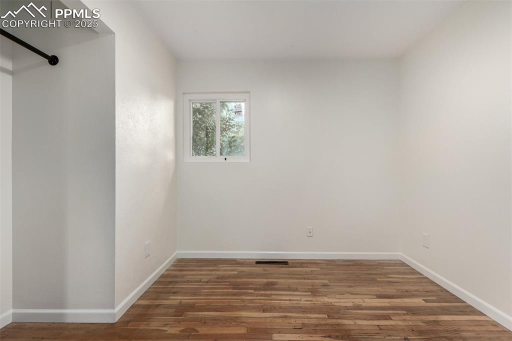 1216 Osgood Road Colorado Springs, CO 80915 - Photo 17 of 36 a view of an empty room with wooden floor and a window