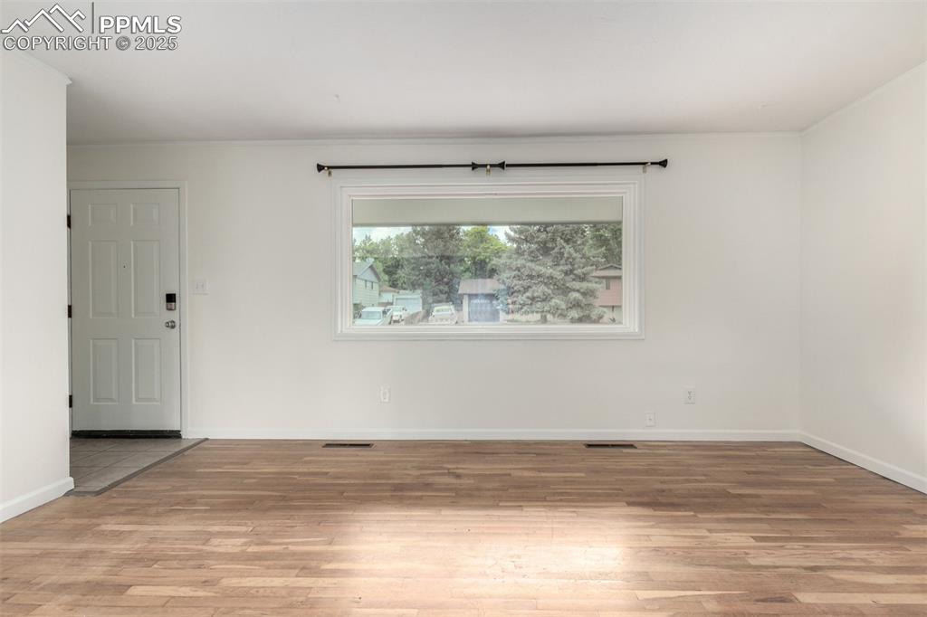 1216 Osgood Road Colorado Springs, CO 80915 - Photo 5 of 36 an empty room with wooden floor and windows