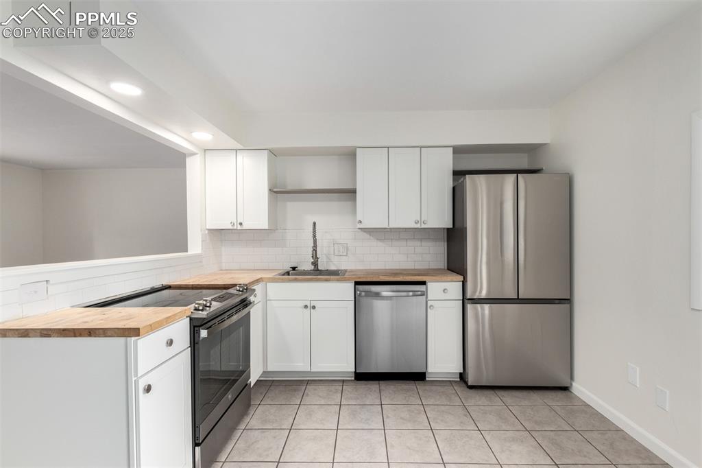 1216 Osgood Road Colorado Springs, CO 80915 - Photo 8 of 36 a kitchen with stainless steel appliances granite countertop a sink stove and refrigerator