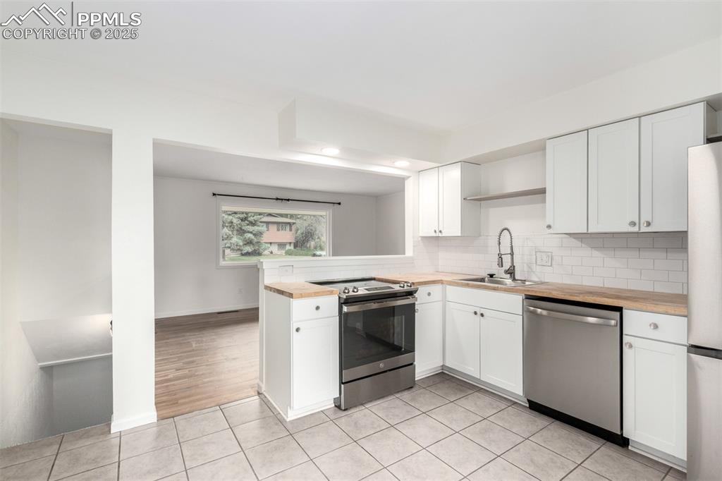 1216 Osgood Road Colorado Springs, CO 80915 - Photo 9 of 36 a kitchen with a stove top oven sink and cabinets
