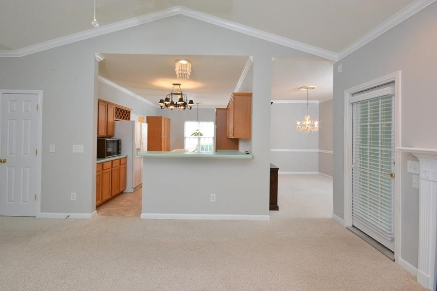 710 Latta Circle Durham, NC 27712 - Photo 3 of 42 wooden floor in a room with a mirror and chandelier