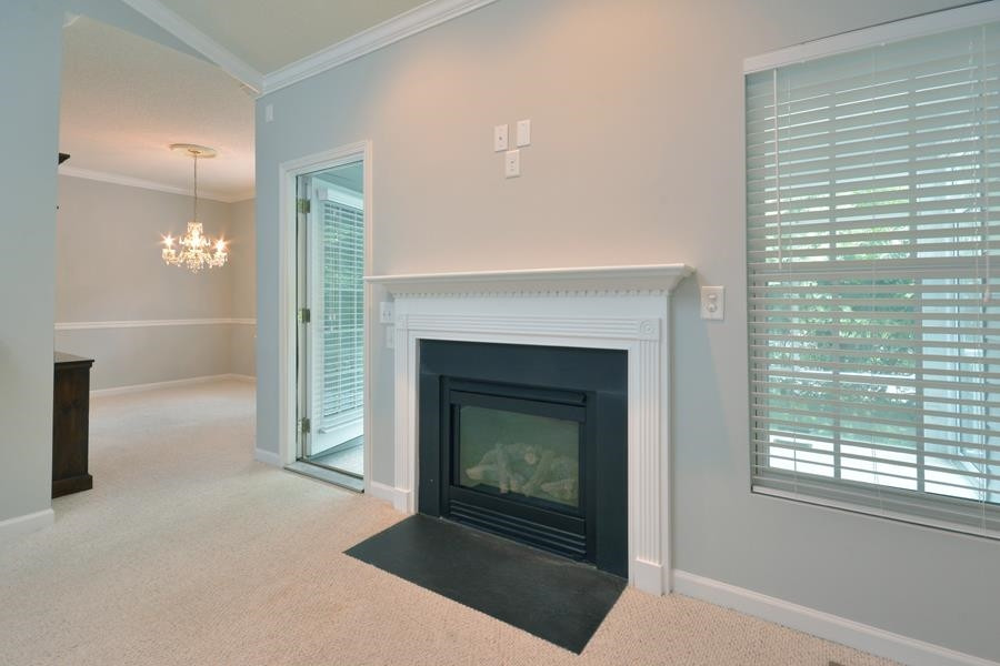 710 Latta Circle Durham, NC 27712 - Photo 6 of 42 a living room with a fireplace and a floor to ceiling window