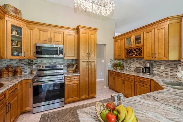 a kitchen with stainless steel appliances a stove top oven a refrigerator and a window