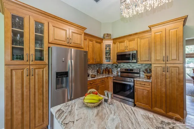 a kitchen with stainless steel appliances granite countertop a sink refrigerator and cabinets