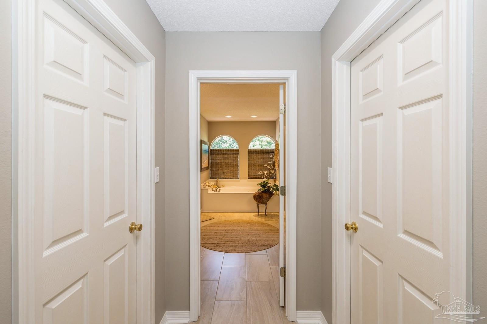 2808 P.G.A Boulevard Navarre, FL 32566 - Photo 24 of 54 a view of a hallway with wooden floor and a livingroom