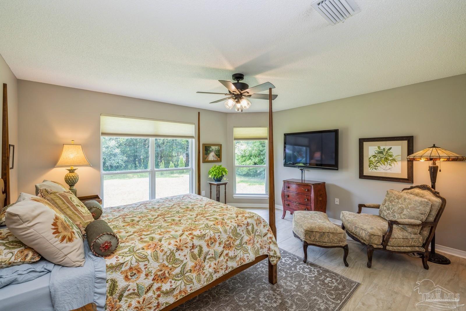 2808 P.G.A Boulevard Navarre, FL 32566 - Photo 33 of 54 a spacious bedroom with a bed and a couch