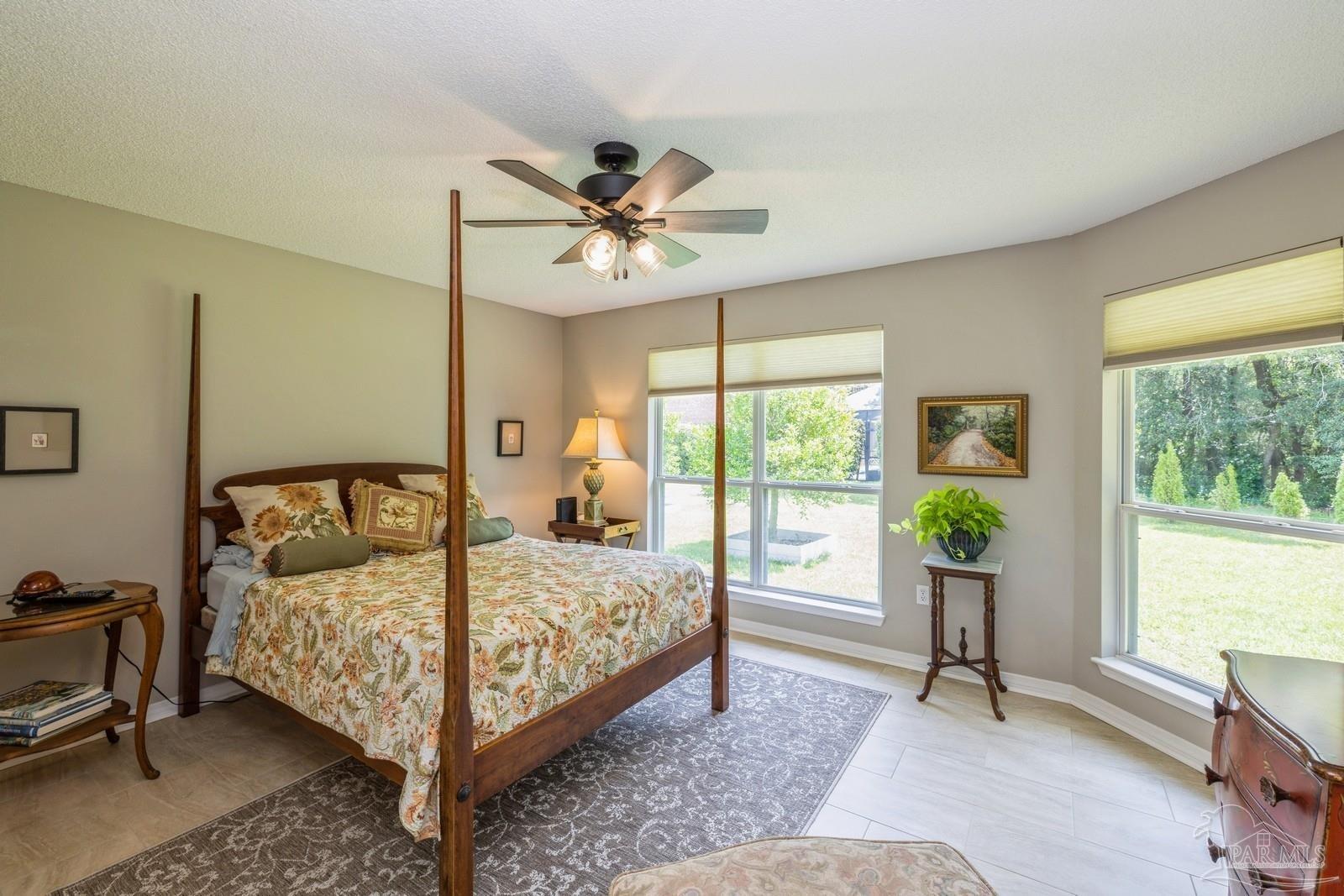 2808 P.G.A Boulevard Navarre, FL 32566 - Photo 34 of 54 a bedroom with a large bed and a chandelier