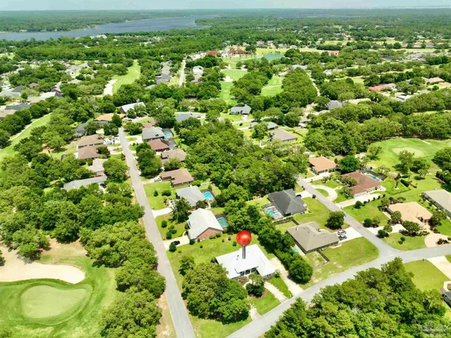 an aerial view of residential houses with outdoor space and trees