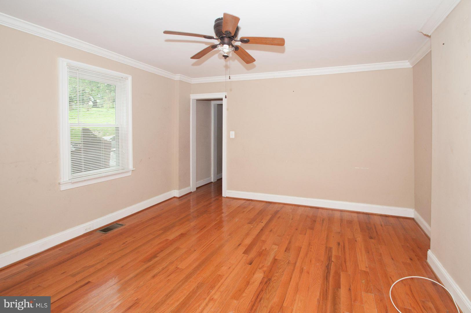 6216 Falls Road Baltimore, MD 21209 - Photo 2 of 8 an empty room with wooden floor and windows