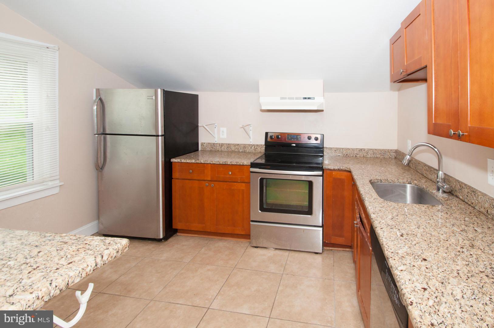 6216 Falls Road Baltimore, MD 21209 - Photo 4 of 8 a kitchen with a stove a sink and a refrigerator