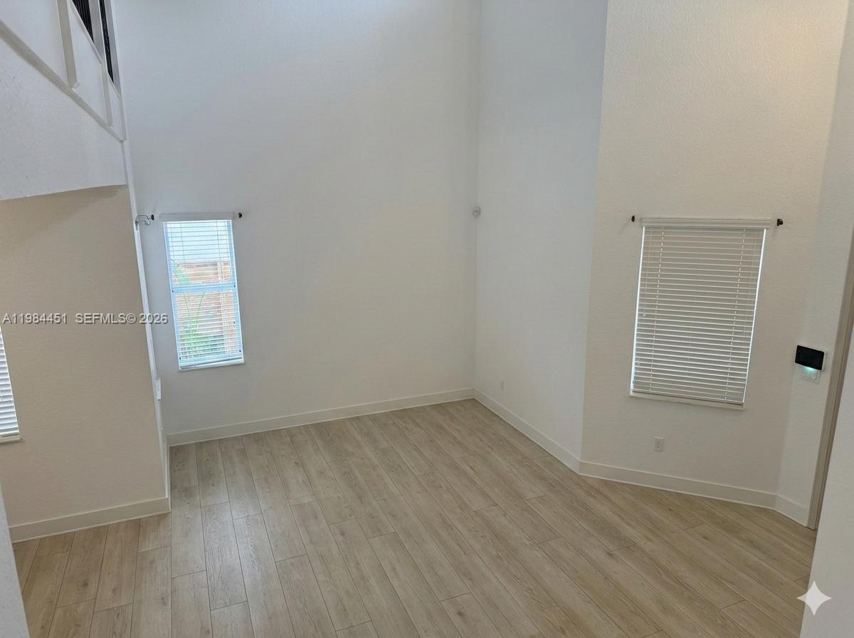 16364 Southwest 63rd Terrace Miami, FL 33193 - Photo 5 of 20 an empty room with wooden floor and windows