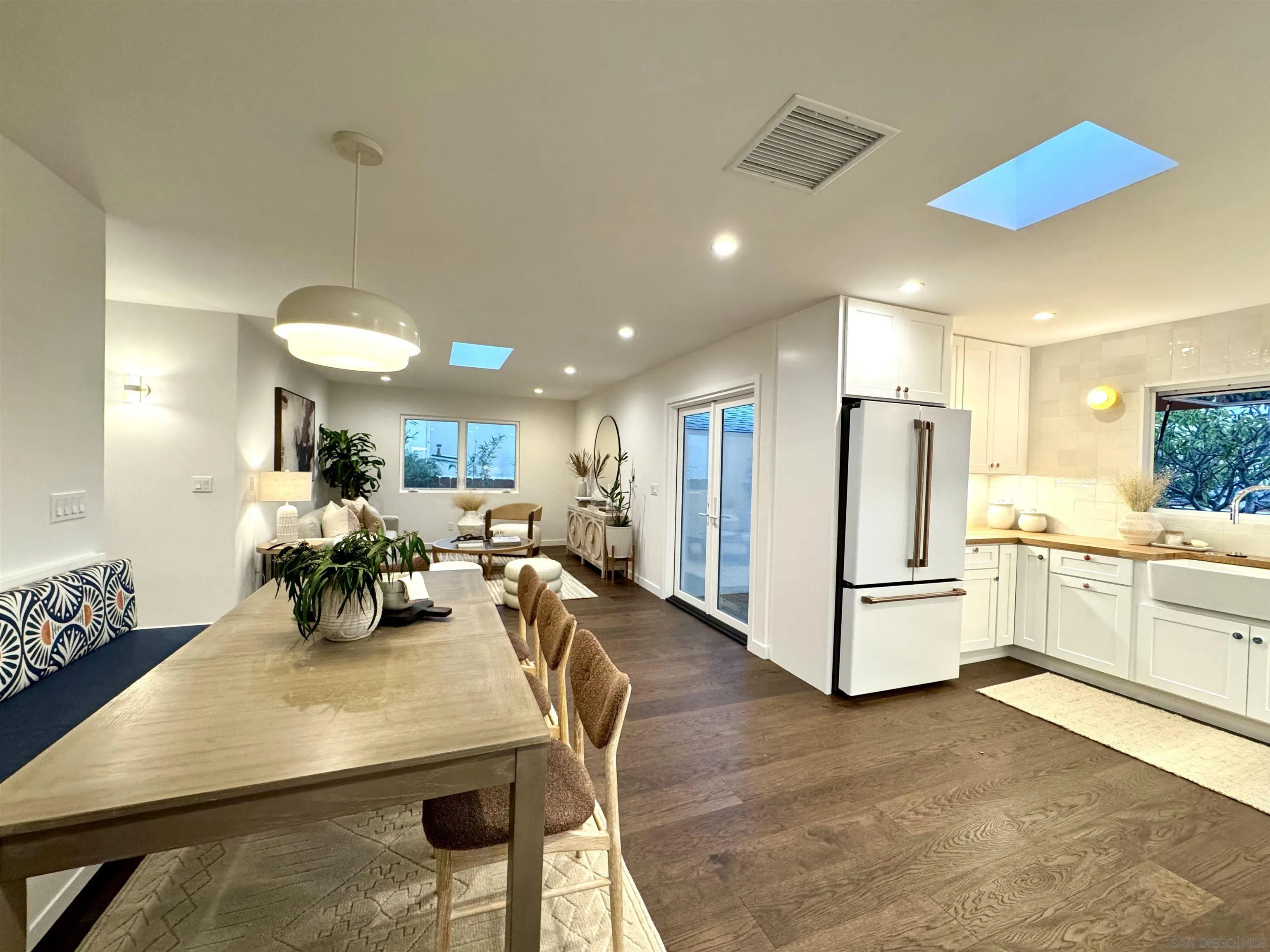 1025 Wilbur Avenue San Diego, CA 92109 - Photo 52 of 52 a kitchen with stainless steel appliances kitchen island granite countertop a refrigerator a stove a sink dishwasher and white cabinets with wooden floor