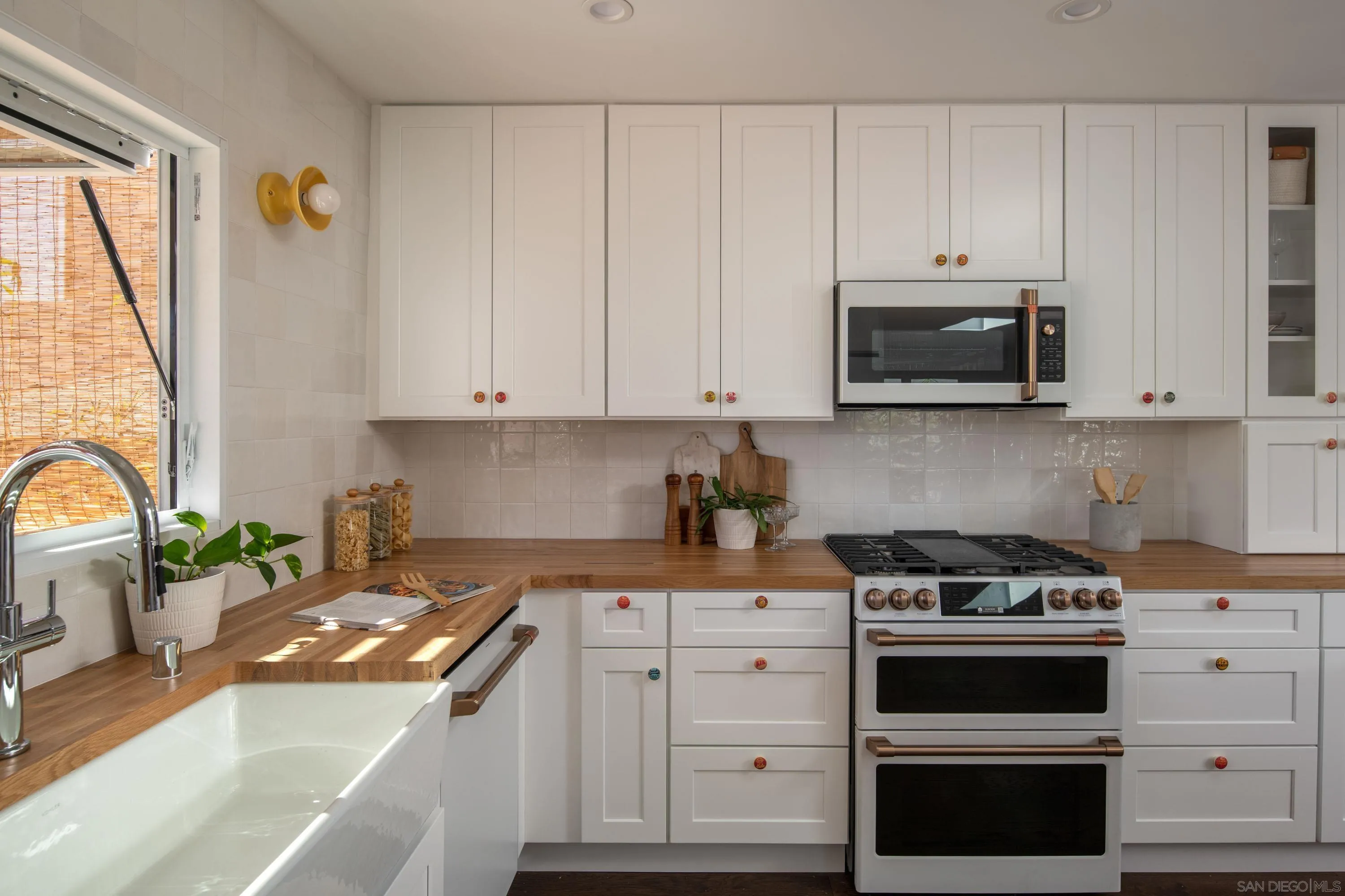 1025 Wilbur Avenue San Diego, CA 92109 - Photo 8 of 52 a kitchen with granite countertop white cabinets and stainless steel appliances