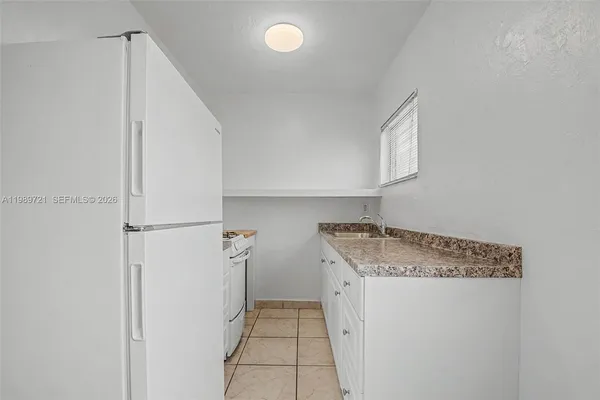 a kitchen with granite countertop a sink a stove and cabinets