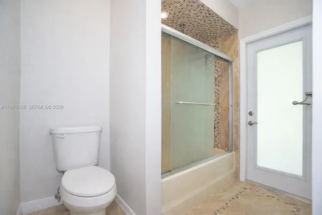 a bathroom with a granite countertop toilet and a shower