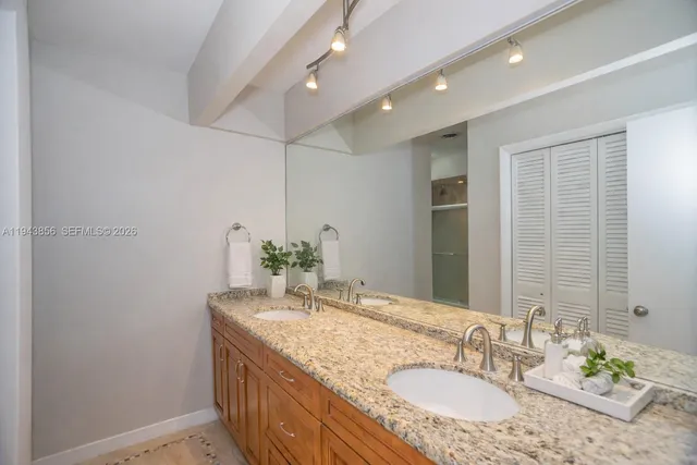 a bathroom with a granite countertop sink and a mirror