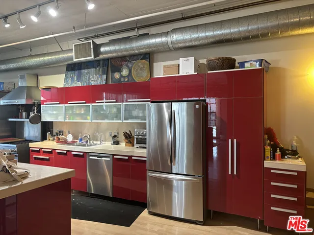 a kitchen with granite countertop a refrigerator and a stove top oven