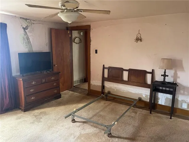 a view of a room with a chandelier fan and a window