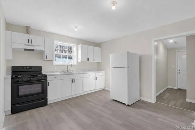 a view of a kitchen with a refrigerator and a sink